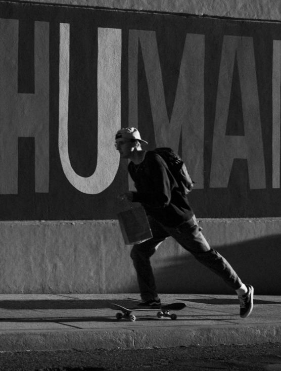 a-man-riding-a-skateboard-down-a-sidewalk.jpg a man riding a skateboard down a sidewalk