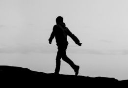 a-person-standing-on-top-of-a-hill-near-the-ocean.jpg a person standing on top of a hill near the ocean
